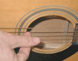 Strumming a guitar with your index fingernail